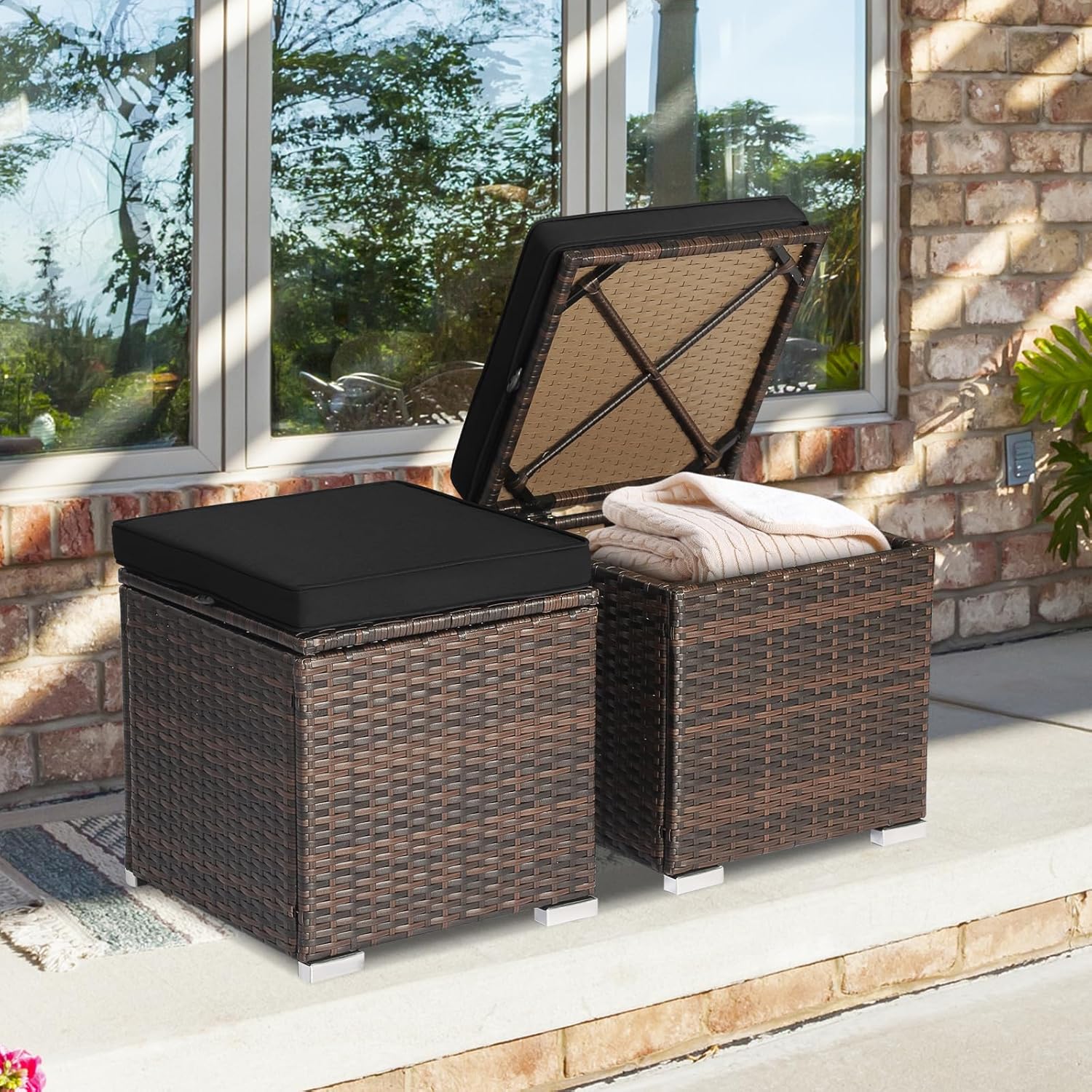A wicker ottoman with a storage lid, topped with a tray and a teapot, on a tiled balcony. Floor cushions and a city skyline create a cozy urban scene.